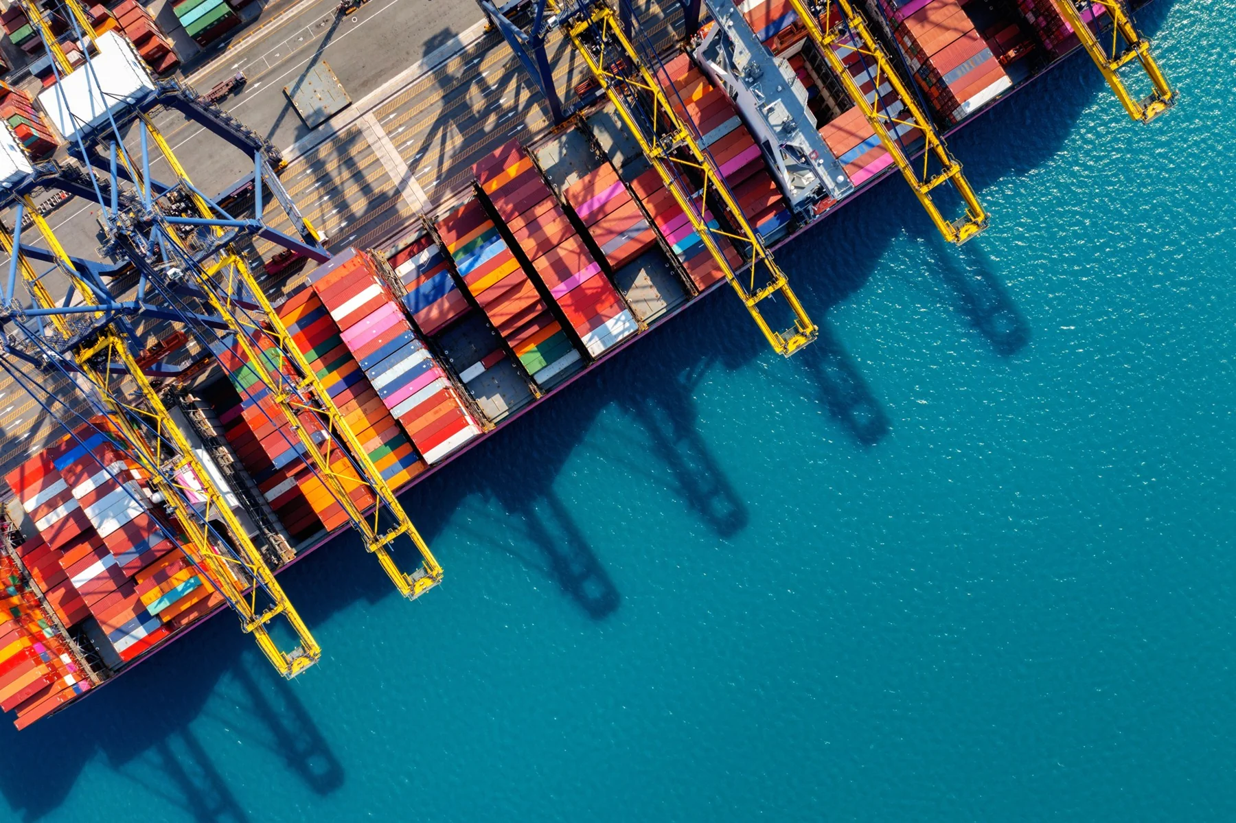 Aerial view of a cargo vessel beside a container terminal